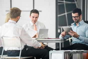 Group of corporate people discussing facility management software by an office table