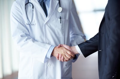 doctor handshake with a patient at doctors bright modern office in hospital-1