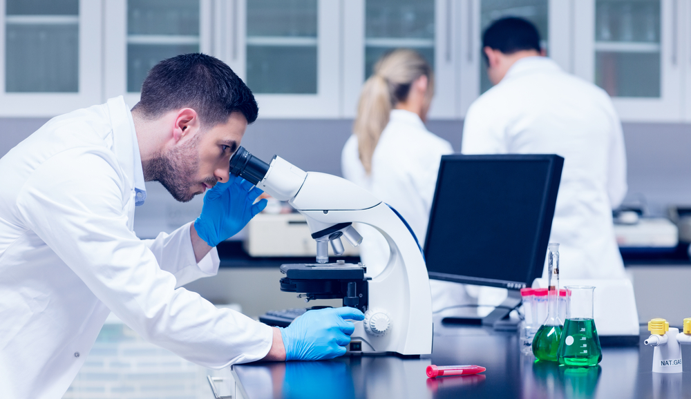 University science lab with safety signage and maintenance technician inspecting equipment